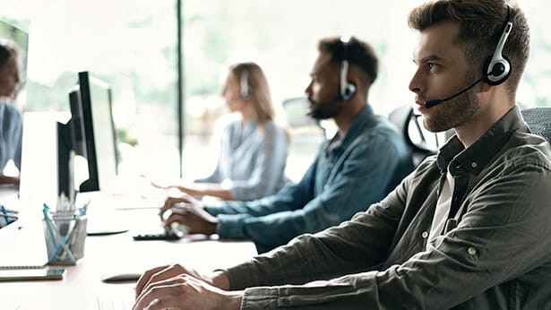 Photo of people wearing headsets in a call center